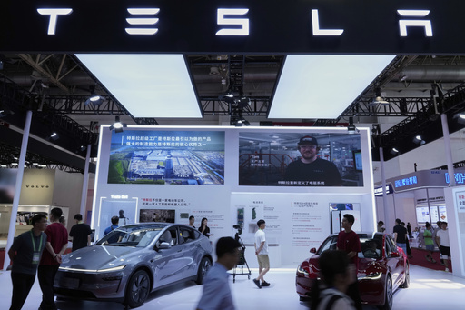 People visit a booth of Tesla during the 3rd China International Supply Chain Expo at the China International Exhibition Center, in Beijing, China, Friday, July 18, 2025. (AP Photo/Mahesh Kumar A.)
