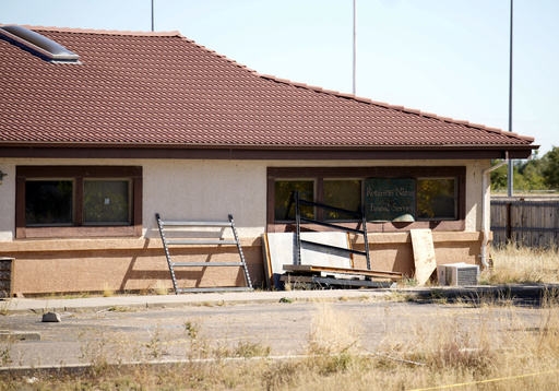 FILE - A sign covers the broken back window of the Return to Nature Funeral Home in Penrose, Colo., Oct. 16, 2023. (AP Photo/David Zalubowski, File)