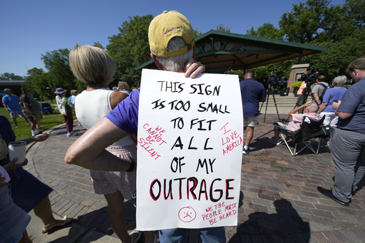 A local resident listen to a speech during an Iowa Democratic Party rally, Thursday, July 3, 2025, in Windsor Heights, Iowa. (AP Photo/Charlie Neibergall)