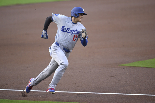 Los Angeles Dodgers' Shohei Ohtani rounds third base before scoring on a double hit by Freddie Freeman, not pictured, during the first inning of a baseball game against the San Diego Padres, Monday, June 9, 2025, in San Diego. (AP Photo/Orlando Ramirez)