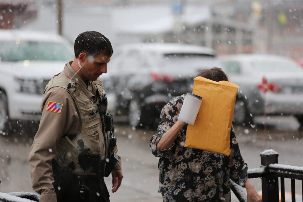 Hughes County Deputy Josh Larson guides Lonna Carroll into the courthouse in Pierre on April 2, 2025. (Joshua Haiar/South Dakota Searchlight)