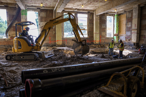 An excavator works on the ground floor of the 1951 Constitution Avenue Building as renovations continue on the Federal Reserve, Thursday, July 24, 2025, in Washington. (Andrew Harnik/Pool Photo via AP)