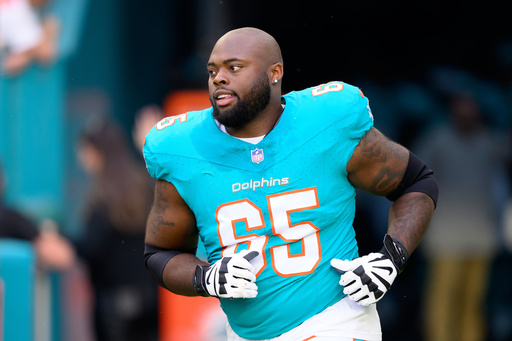 FILE - Miami Dolphins offensive lineman Robert Jones (65) runs onto the field during player introductions before an NFL football game against the San Francisco 49ers, Sunday, Dec. 22, 2024, in Miami Gardens, Fla. (AP Photo/Doug Murray, file)