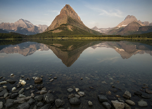 In this photo provided by the National Park Service, Grinnell Peak, flanked by Mount Gould to the left and Mount Wilbur to the right, is reflected on the surface of Swiftcurrent Lake at Glacier National Park near West Glacier, Montana, May 28, 2014. (Tim Rains/NPS Photo via AP)