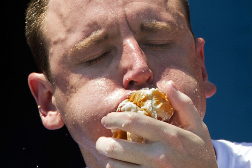FILE - Five-time reigning champion Joey Chestnut competes in the Nathan's Famous Hot Dog Eating World Championship, July 4, 2012, at Coney Island, in the Brooklyn borough of New York. (AP Photo/John Minchillo, File)
