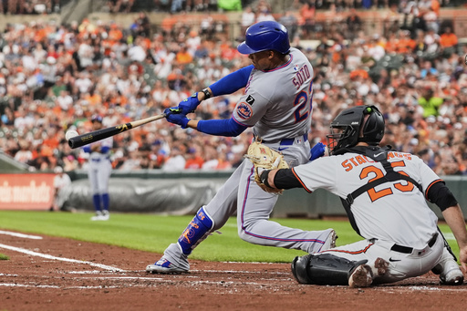 New York Mets' Juan Soto, left, hits a single during the fourth inning of a baseball game against the Baltimore Orioles, Tuesday, July 8, 2025, in Baltimore. (AP Photo/Stephanie Scarbrough)
