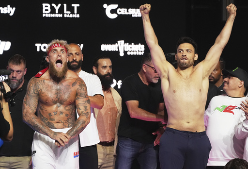 FILE - Jake Paul, front left, and Julio Cesar Chavez Jr., front right, pose for photographers following a ceremonial weigh-in ahead of their cruiserweight boxing match, in Anaheim, Calif., June 27, 2025. (AP Photo/Chris Pizzello, File)