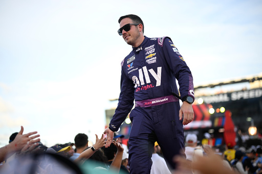 FILE - Alex Bowman interacts with spectators while walking down a runway during driver introductions before a NASCAR Cup Series auto race at Daytona International Speedway, Aug. 24, 2024, in Daytona Beach, Fla. (AP Photo/Phelan M. Ebenhack, File)