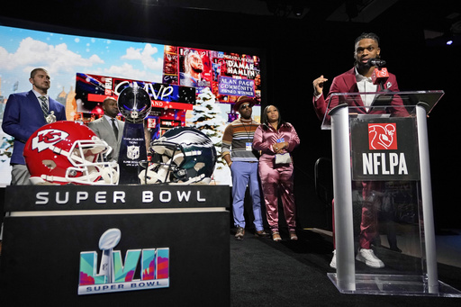 FILE - Buffalo Bills' Damar Hamlin speaks after being introduced as the winner of the Alan Page Community Award during a news conference ahead of the Super Bowl 57 NFL football game Feb. 8, 2023, in Phoenix. Damar's parents Mario and Nina Hamlin, center, look on with NFLPA President JC Tretter, left. (AP Photo/Mike Stewart, File)