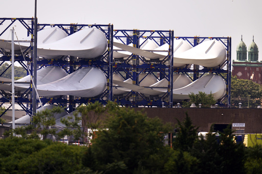FILE - Giant wind turbine blades for the Vineyard Winds project are stacked on racks in the harbor, July 11, 2023, in New Bedford, Mass. (AP Photo/Charles Krupa, File)