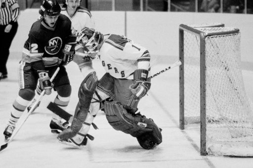FILE - New York Islanders' Mike Bossy, left, watches the puck about to be deflected by New York Rangers goalie Wayne Thomas during an NHL hockey game at New York's Madison Square Garden, Nov. 12, 1978. (AP Photo/Ray Stubblebine, File)