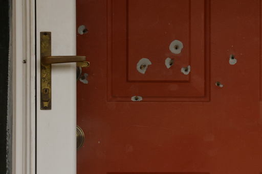 Bullet holes mark the front door of the house of Minnesota state Sen. John Hoffman and his wife who were shot earlier in the day, Saturday, June 14, 2025, in Champlin, Minn. (AP Photo/Bruce Kluckhohn)