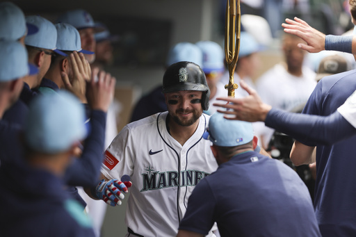 Seattle Mariners designated hitter Cal Raleigh celebrates in the dugout after hitting a solo home run during the sixth inning of a baseball game against the Pittsburgh Pirates, Friday, July 4, 2025, in Seattle. (AP Photo/Ryan Sun)