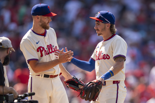 Philadelphia Phillies' Zack Wheeler, left, celebrates with Bryson Stott, right, following a baseball game against the Cincinnati Reds, Sunday, July 6, 2025, in Philadelphia. (AP Photo/Chris Szagola)
