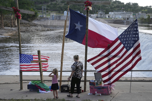 Nancy Epperson, right, and Brooklyn Pucek, 6, visit a memorial for flood victims along the Guadalupe River on Thursday, July 10, 2025, in Kerrville, Texas. (AP Photo/Gerald Herbert)