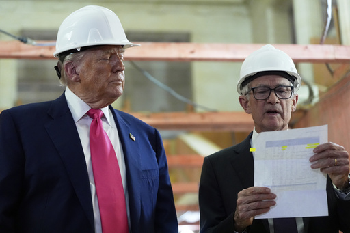 Federal Reserve Chairman Jerome Powell looks over a document of cost figures as President Donald Trump watches during a visit to the Federal Reserve, Thursday, July 24, 2025, in Washington. (AP Photo/Julia Demaree Nikhinson)