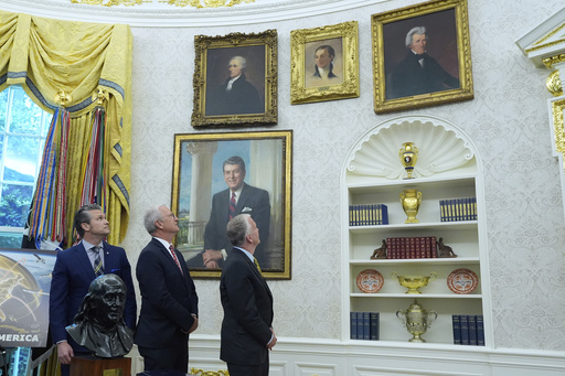 FILE - From left, Defense Secretary Pete Hegseth, Sen. Kevin Cramer, R-N.D., and Sen. Dan Sullivan, R-Alaska, look at portraits of former presidents as President Donald Trump speaks in the Oval Office of the White House, in Washington, May 20, 2025. (AP Photo/Alex Brandon, File)