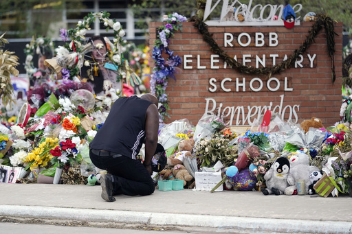 FILE - Reggie Daniels pays his respects a memorial at Robb Elementary School, Thursday, June 9, 2022, in Uvalde, Texas, created to honor the victims killed in the recent school shooting. (AP Photo/Eric Gay, file)