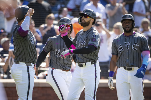 New York Mets' Brandon Nimmo celebrates his grand slam with the scorers, Pete Alonso, Fransisco Lindor and Starling Marie, during the first inning of a baseball game against the New York Yankees, Saturday, July 5, 2025, in New York. (AP Photo/Angelina Katsanis)