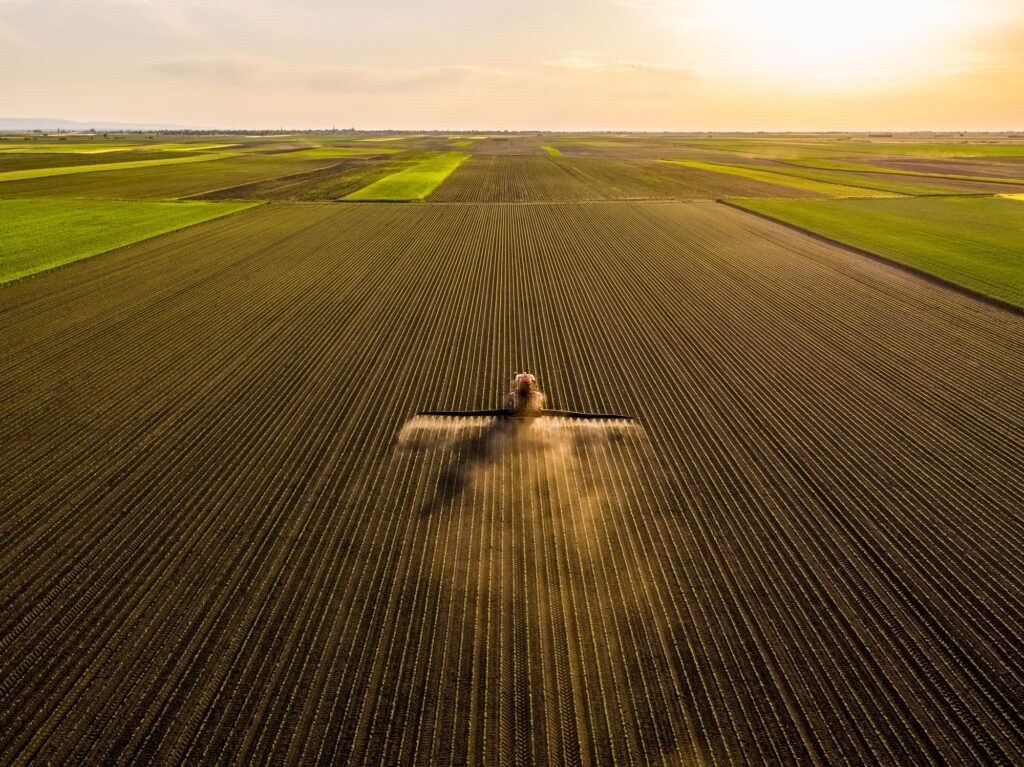 A farmer on a tractor sprays soybean crops. (Photo by Westend61/Getty Images)