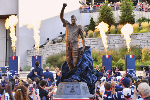 A bronze statue of former New England Patriots quarterback Tom Brady is unveiled in Patriot Place Plaza before an NFL preseason football game between the Washington Commanders and the New England Patriots Friday, Aug. 8, 2025, in Foxborough, Mass. (AP Photo/Steven Senne)