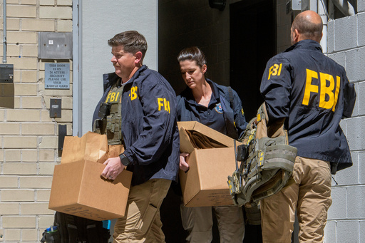 FBI agents carry boxes from former National Security Advisor John Bolton's office in Washington, Friday, Aug. 22, 2025. (AP Photo/Rod Lamkey, Jr.)