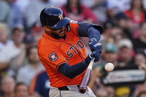 Houston Astros designated hitter Carlos Correa connects on a flyout in the second inning of a baseball game against the Boston Red Sox at Fenway Park, Friday, Aug. 1, 2025, in Boston. (AP Photo/Charles Krupa)