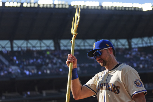 Seattle Mariners catcher Cal Raleigh lifts the trident to celebrate a win over the Athletics in a baseball game Sunday, Aug. 24, 2025, in Seattle. (AP Photo/Lindsey Wasson)