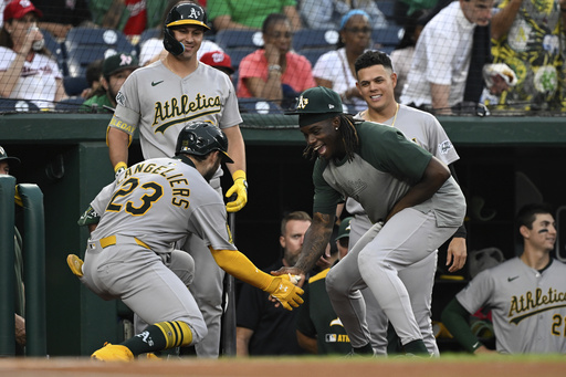 Athletics' Shea Langeliers (23) is greeted by Lawrence Butler, right, after hitting a home run against Washington Nationals pitcher MacKenzie Gore during the first inning of a baseball game in Washington, Tuesday, Aug. 5, 2025. (AP Photo/Terrance Williams)