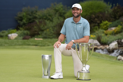 Scottie Scheffler poses with the trophies after winning the BMW Championship golf tournament Sunday, Aug. 17, 2025, in Owings Mills, Md. (AP Photo/Stephanie Scarbrough)