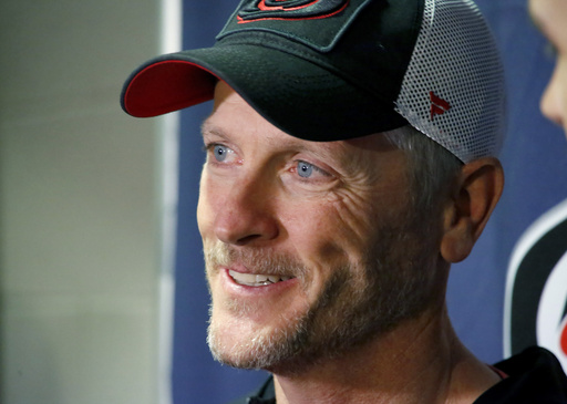 FILE - Tom Dundon, majority owner of the Carolina Hurricanes talks to the media about his $250 million investment in the Alliance of American Football league before the start of an NHL hockey game between the New York Rangers and the Carolina Hurricanes in Raleigh, N.C, Tuesday, Feb. 19, 2019. (AP Photo/Chris Seward, File)