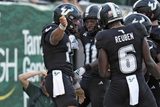 South Florida quarterback Byrum Brown (17) celebrates his touchdown against Boise State with wide receiver Keshaun Singleton (11) and wide receiver Mudia Reuben (6) during the first half of an NCAA college football game Thursday, Aug. 28, 2025, in Tampa, Fla. (AP Photo/Chris O'Meara)