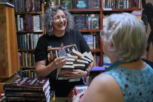 Owner Michelle Souliere, left, chats with a frequent customer at the Green Hand Bookstore in Portland, Maine, on Thursday, Aug. 7, 2025. (AP Photo/Robert F. Bukaty)