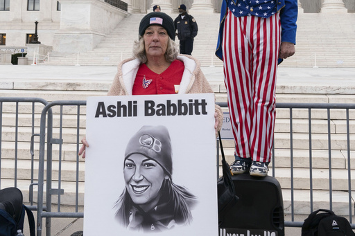 FILE - Micki Witthoeft, center, mother of Ashli Babbitt, the woman fatally shot by police inside the U.S. Capitol during the Jan. 6, 2021, riot, joins protesters outside of the Supreme Court on the second anniversary of the Jan. 6, assault on the U.S. Capitol, in Washington, Jan. 6, 2023. (AP Photo/Jose Luis Magana, File)