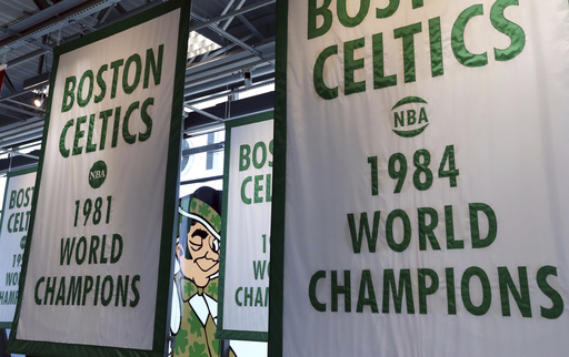 FILE - Lucky the Leprechaun, the Boston Celtics team logo, peers out from in between Celtics championship banners hanging in their new basketball team practice facility, Tuesday, June 19, 2018, in Boston. (AP Photo/Elise Amendola, File)