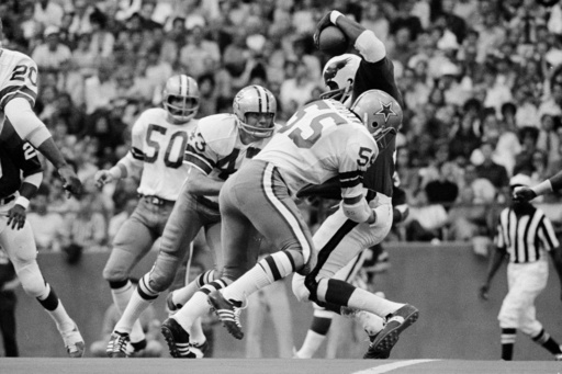 FILE - Philadelphia Eagles wide receiver Harold Carmichael is swarmed by the Dallas Cowboys defense, including linebacker Lee Roy Jordan (55) during third period of an NFL football game in Irving, Texas, Nov. 15, 1971. (AP Photo/File)
