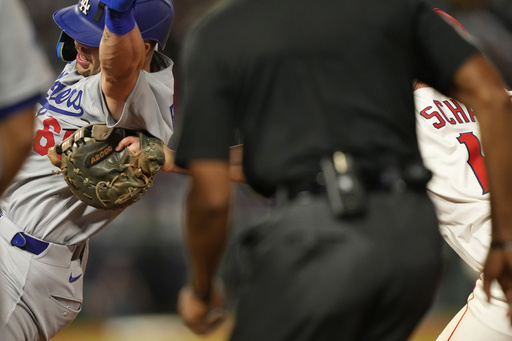 Los Angeles Dodgers' Dalton Rushing, left, is tagged out by Los Angeles Angels first baseman Nolan Schanuel for the last out of a triple play during the sixth inning of a baseball game Tuesday, Aug. 12, 2025, in Anaheim, Calif. (AP Photo/Mark J. Terrill)