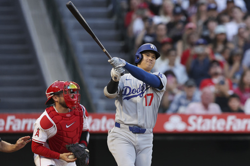 Los Angeles Dodgers designated hitter Shohei Ohtani (17) strikes out swinging as Los Angeles Angels catcher Travis d'Arnaud, left, prepares to throw the ball during the third inning of a baseball game, Monday, Aug. 11, 2025, in Anaheim, Calif. (AP Photo/Jessie Alcheh)