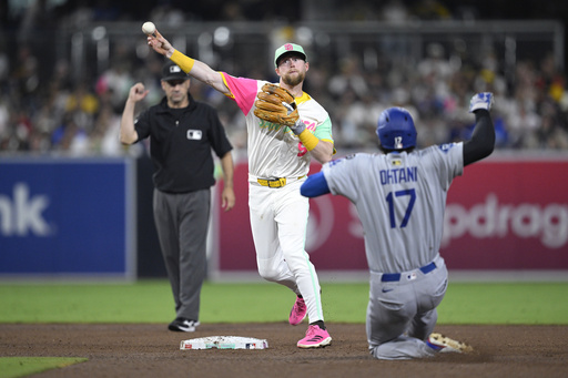 San Diego Padres second baseman Jake Cronenworth, center, throws to first base after forcing out Los Angeles Dodgers' Shohei Ohtani (17) at second base to complete a double play during the sixth inning of a baseball game Friday, Aug. 22, 2025, in San Diego. (AP Photo/Orlando Ramirez)