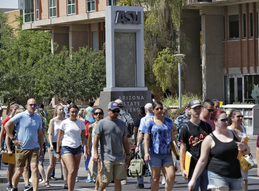 FILE - Pedestrians cross University Ave on the campus of Arizona State University in Tempe, Ariz., July 25, 2018. (AP Photo/Matt York, File)