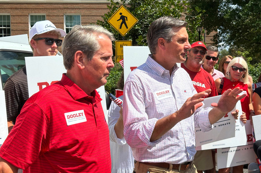 Republican U.S. Senate candidate Derek Dooley speaks, accompanied by Georgia Gov. Brian Kemp, foreground, at the University of Georgia in Athens, Ga., on Saturday, Aug. 30, 2025. (AP Photo/Jeff Amy)