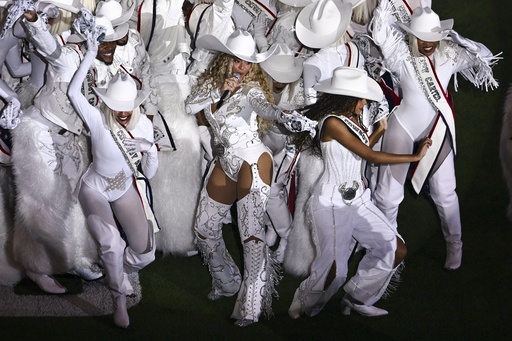 FILE - Beyoncé, center, is joined by her daughter Blue Ivy, right, during a halftime performance in an NFL football game between the Baltimore Ravens and the Houston Texans, Dec. 25, 2024, in Houston. (AP Photo/Maria Lysaker, File)