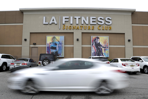 FILE - A vehicle drives near the side of the building of an LA Fitness gym, on April 19, 2018, in Secaucus, N.J. (AP Photo/Julio Cortez, File)