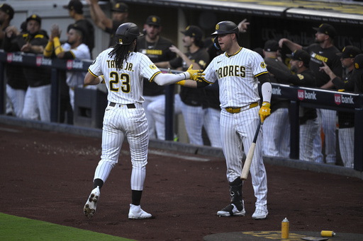 San Diego Padres' Fernando Tatis Jr. (23) is congratulated by Gavin Sheets after scoring on a single by Ryan O'Hearn during the first inning of a baseball game against the San Francisco Giants, Wednesday, Aug. 20, 2025, in San Diego. (AP Photo/Orlando Ramirez)