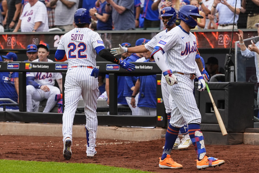 New York Mets'Juan Soto (22) is greeted after hitting a home run during the ninth inning of a baseball game against the Cleveland Guardians, Wednesday, Aug. 6, 2025, in New York. (AP Photo/Yuki Iwamura)