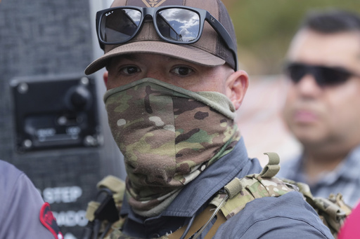 A federal agent escorts a man to a bus after he was detained following an appearance at immigration court, Monday, July 28, 2025, in San Antonio. (AP Photo/Eric Gay)