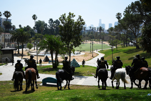 FILE - Federal agents ride on horseback at MacArthur Park, July 7, 2025, in Los Angeles. (AP Photo/Damian Dovarganes, File)