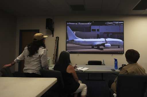 Immigrant rights advocates monitor a webcam available to the public showing a U.S. Immigration and Customs Enforcement flight departing from King County International Airport-Boeing Field, Tuesday, Aug. 19, 2025, in Seattle. (AP Photo/Lindsey Wasson)