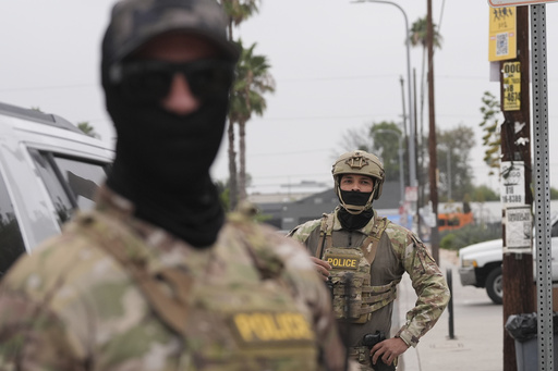 Federal agents stage outside a Home Depot during an operation Friday, Aug. 15, 2025, in Los Angeles. (AP Photo/Gregory Bull)