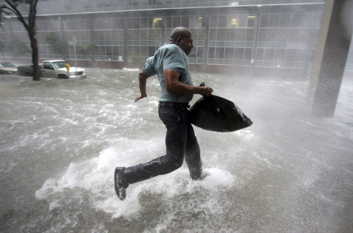 FILE - Arnold James tries to keep his feet as a strong gust nearly blows him over as makes his way on foot to the Louisiana Superdome in New Orleans, Aug. 29, 2005. (AP Photo/Dave Martin, File)